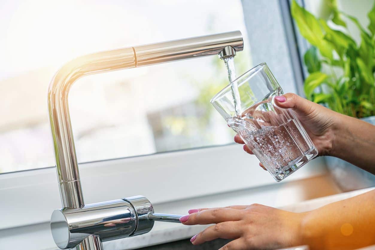 Pouring Water Into Glass From Kitchen Faucet